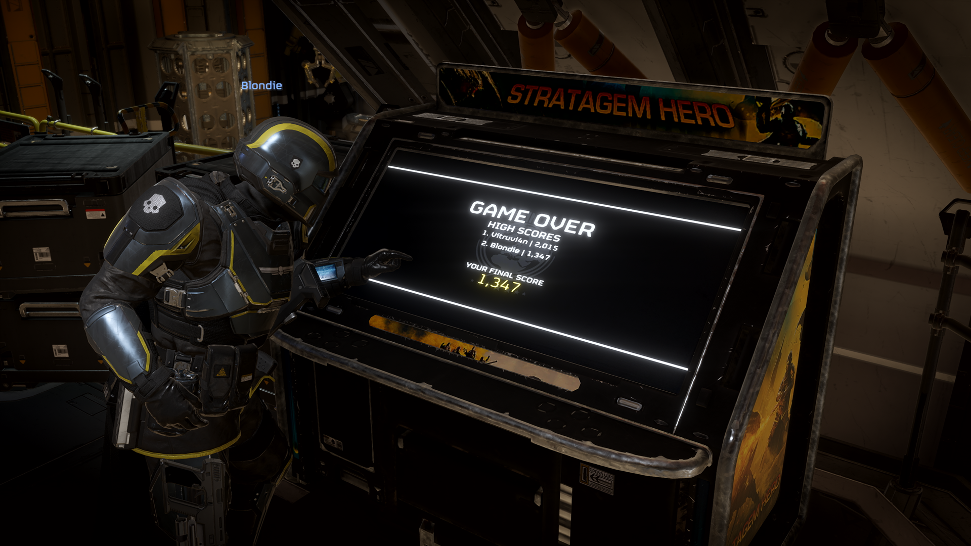 A Helldiver at the Stratagem Hero arcade cabinet aboard a Super Destroyer, showing a Game Over screen with high scores